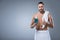 man with bath towel on shoulder holding bottle with tooth rinse in hand,