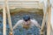 Man bathes into cold water of ice-hole on Epiphany day. Traditional ice swimming in Orthodox church Holy Epiphany Day. Russia