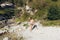 Man bathes in a mountain stream falls on the stones in nature