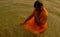 A man is bathing in Ganga River in Varanasi