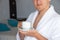 Man in bathrobe with cup of coffee in hotel room