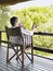 Man In Bathrobe Sitting In Terrace With Feet Up