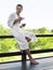 Man In Bathrobe On Terrace Railing With Tea