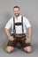 Man in bavarian traditional lederhosen kneeling