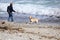 Man On Beach Throwing Stick For Dog