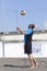 Man beach volleyball player serving ball