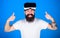Man with beard and cheerful face enjoying virtual reality experience. Hipster with stylish beard and big smile happy