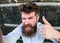 Man, with beard on cheerful face shows thumb up gesture, black marble background. Hipster, tourist with tousled hair and