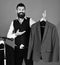 Man with beard by clothes rack. Fashion and individual style