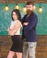 Man with beard and girl teacher stand in classroom, chalkboard on background. Partners concept. Lady and hipster