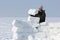 The man with a beard in a gray cap building an igloo