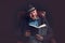 Man with beard and hat sitting on leather chair reading book