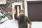 Man with beard in his cap throws snowballs in yard