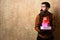 Man with beard holds boxes on beige wall background