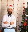 Man with beard holds champagne glass. Santa Claus in hat