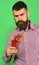 Man with beard holds glass of tomato juice with berries
