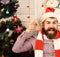 Man with beard holds golden Christmas balls as earrings