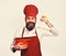 Man with beard holds red pot on white background.