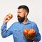 Man with beard holds wicker bowl with apple fruits