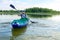 A man with a beard in an inflatable boat swings an oar