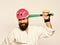 Man with beard in kimono and pink helmet on white background. MMA sports concept. Combat master gets ready to fight