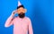 Man with beard and mustache on calm face lonely on his birthday, blue background. Guy in party hat celebrates alone