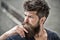 Man with beard and mustache looks thoughtful or troubled Bearded man on concentrated face touches beard. Hipster with