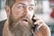 Man with beard and mustache mobile phone conversation defocused background. Bearded man hold mobile phone. Hipster