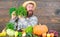 Man with beard proud of his harvest wooden background. Organic fertilizers make harvest healthy and rich. Farmer with