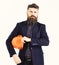 Man with beard and serious face looks. Building and engineering concept. Manager wears smart suit, tie and orange