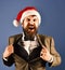 Man with beard in smart suit and Santa hat.