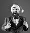 Man with beard in smart suit and Santa hat.