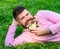 Man with beard on smiling face enjoy nature. Bearded man with daisy flowers lay on meadow, lean on hand, grass