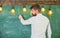 Man with beard stand in front of chalkboard, rear view. Guy busy with writing on chalkboard surface. Bearded hipster in