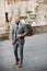 A man with a beard in a strict grey three-piece suit with a tie in the old town of Sirmione, a Stylish man in a grey suit in Italy