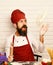 Man with beard throws pizza dough up on white background