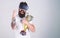 Man with beard in virtual reality glasses holds goblet, light background. Hipster on happy face squeezing fist as