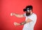 Man with beard in VR glasses driving car, red background. Virtual racing concept. Guy play racing game in VR. Hipster on