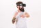 Man with beard in VR glasses fighting, white background. VR gadget concept. Guy with head mounted display fight in