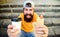 Man bearded enjoy quick lunch stairs background. Hipster eat hot dog drink coffee. Hipster enjoy hot dog drink paper cup