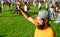 Man bearded hipster in front of crowd people green field background. Urban event celebration. Man waving hand sunny day