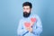 Man bearded hipster with heart valentine card. Celebrate love. Guy attractive with beard and mustache in romantic mood