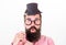 Man bearded hipster hold cardboard top hat and eyeglasses to look smarter white background. Signs someone is smarter