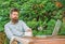 Man bearded hipster make pause for drink coffee and think while sit with laptop. Guy drinks coffee relaxing terrace