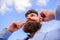 Man bearded hipster twisting mustache sky background. Ultimate moustache grooming guide. Hipster handsome attractive guy