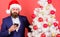 Man bearded hipster wear formal suit and santa hat hold smartphone. Send christmas greeting mobile message. Manager