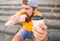 Man bearded shows paper cup drink stairs background. Take coffee with you. Fast food meal for lunch. Hipster bite hot