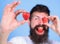 Man bearded winking with red berry, defocused. Perfect strawberry concept. Look at my berry. Hipster happy enjoy juicy