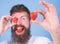 Man bearded winking with red berry, defocused. Perfect strawberry concept. Look at my berry. Hipster happy enjoy juicy
