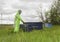 A man in a beekeeper`s protective suit at the apiary. Bright costume, protection from bees, honey collection